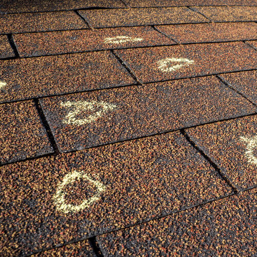 hail damage marked on a shingle roof