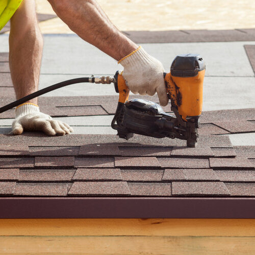 worker installing asphalt shingle roofing